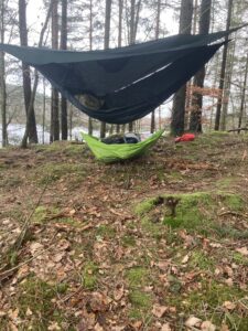 Foto på hängmattan med regntarp i skogen med sjön i bakgrunden