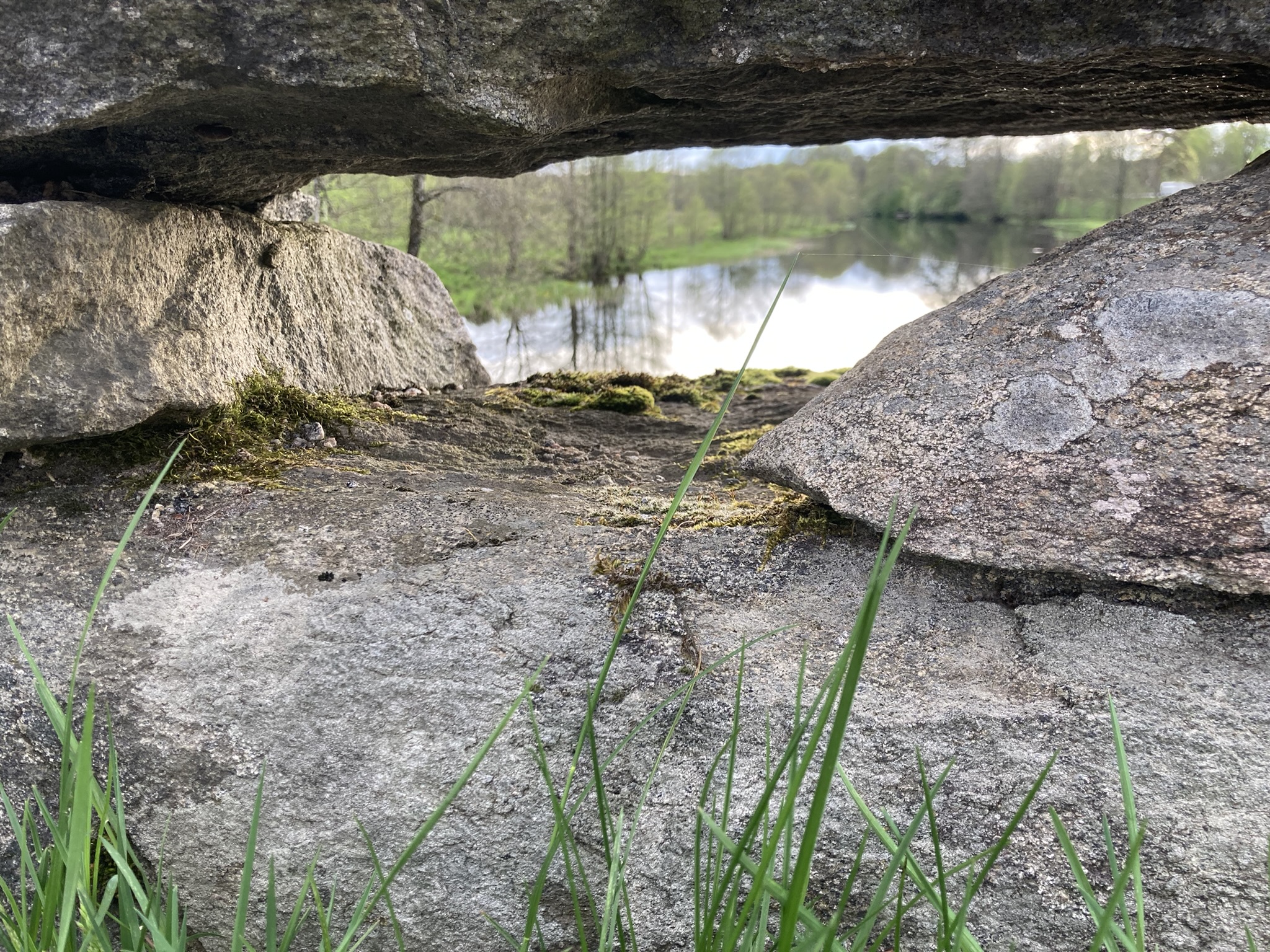 Foto mellan stenarna på en stenbro utsikt över ån och en grön åkant